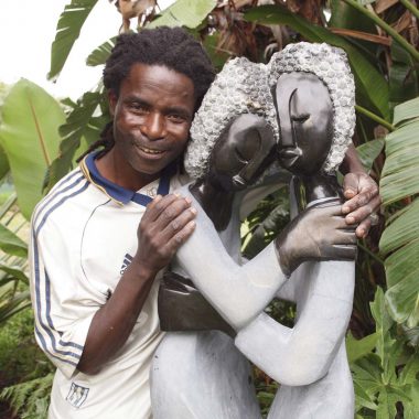 Portrait image of Zimbabwean artist Jetro Zinyeka with one of his sculptures