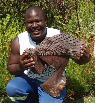 Zimbabwean artist Lovemore Bonjisi with one of his sculptures